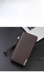 Detail of coffee brown lychee grain leather wallet on office desk with laptop