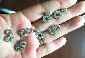 Detailed close-up of silver-plated heart pendants with a yellow gemstone accent