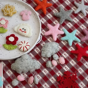 Macro shot of assorted wool felt Christmas ornaments like stars and flowers on a ceramic plate