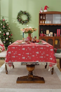 Detail of red Christmas tablecloth with white reindeer motifs and cream tassel fringe