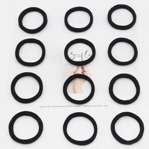 Detail of 12 black high-elastic seamless hair ties arranged in a neat grid pattern
