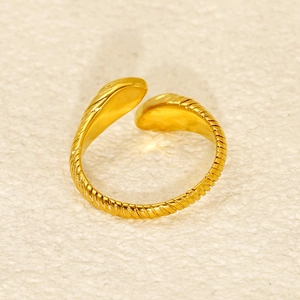 Detailed close-up of golden adjustable ring with elegant spiral engraved textures