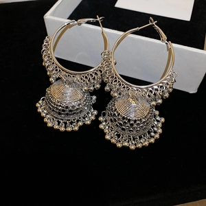 Close-up of vintage silver bohemian hollow jhumka earrings with tassel bell details