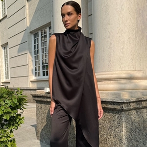 Detail of elegant black sleeveless turtleneck top with side button and satin finish