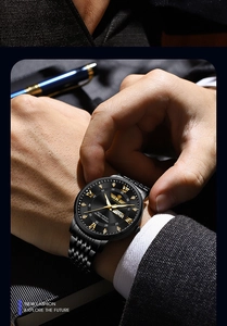 Detail of black stainless steel business watch featuring gold Roman numerals and calendar