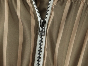 Close-up of olive green striped padded jacket with dark gray metal zipper detail