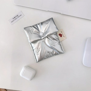 Detail of silver quilted sanitary pad bag with butterfly embroidery and button closure