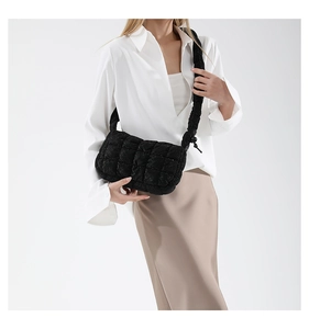 Detail of black quilted cloud bag with padded texture and elegant stitch pattern