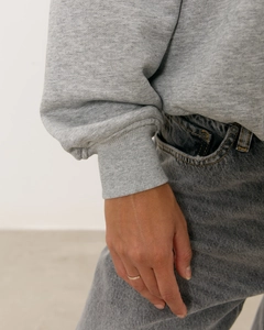 Détail des poignets côtelés d'un sweat-shirt gris vintage et texture de jean denim