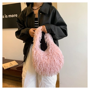 Chic pink faux fur handbag with long fringe detail shown in a lifestyle fashion setting