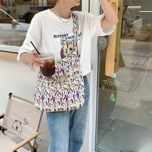 Detail of floral canvas tote bag with vibrant tulip pattern and wide shoulder strap