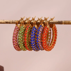 Close-up of multicolored crystal pave earrings in gold plating on a display bar