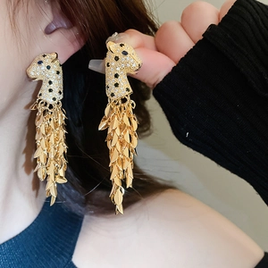 Details von luxuriösen Gold-Leoparden-Ohrringen mit glitzernden Quasten und Kristallen