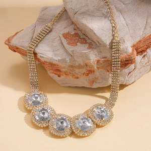 Detailed macro view of large circular rhinestones on a luxury gold statement necklace