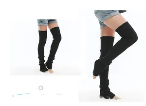 Detail of black ribbed knit over-knee leg warmers with an open-heel design for yoga