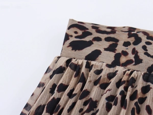 Vista dettagliata del tessuto chiffon leopardato con trama plissettata e cuciture fini