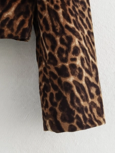 Close-up of leopard print suit sleeve showing soft velvet fabric texture and pattern