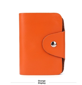 Detail of genuine orange leather card holder featuring fine texture and silver snap button