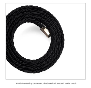 Close-up of black braided thin waist belt with a polished rectangular gold buckle detail