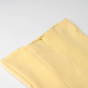 Détail de la fermeture éclair invisible au dos d'un ensemble plissé jaune chic