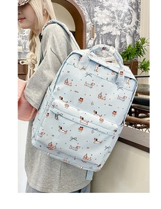 Detail of light blue backpack featuring cartoon dachshund prints and blue decorative bow