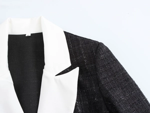 Détail de la texture du tweed noir et du revers blanc contrasté sur le blazer femme