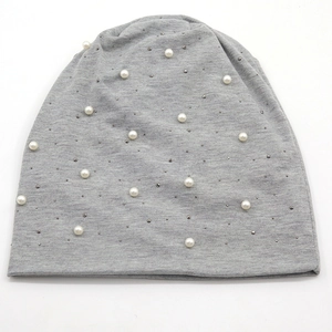 Gros plan détaillé du bonnet en maille grise avec perles blanches et strass brillants