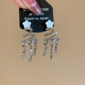 Macro shot of silver S925 star tassel earrings with shimmering cubic zirconia stones