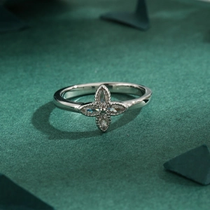 Elegant silver four-leaf clover ring with micro-pave zircons on a dark green background