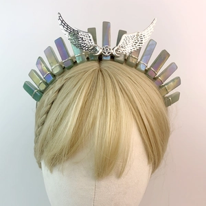 Green crystal bridal crown with silver wings and moon stars on a gold wig mannequin
