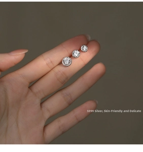 Detailed macro shot of three varying sizes of S999 sterling silver zircon stud earrings
