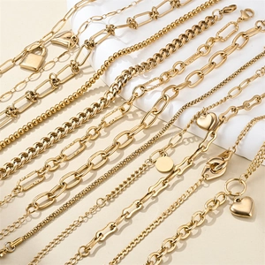 Detail shot of assorted 18K gold plated stainless steel bracelets with charms and lobster clasps