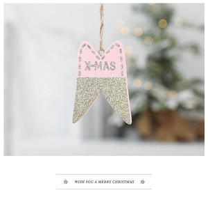 Detail of pink tooth-shaped Christmas ornament with gold glitter and X-MAS text