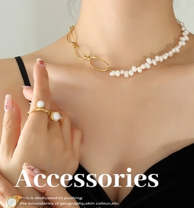 Close-up of French style gold chain necklace and pearl ring on a model neck and hand