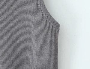 Detail of grey ribbed knit fabric texture and high-quality underarm stitching on a top