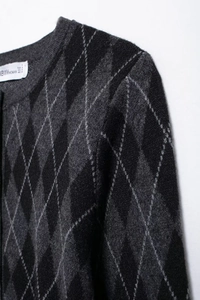 Detail of grey diamond plaid cardigan showing neck label and soft knit texture