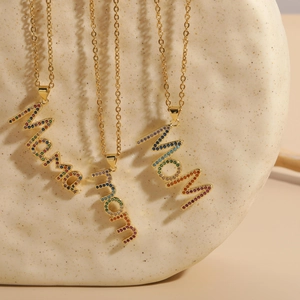 Macro detail of 14K gold plated chain necklaces with Mama and MOM letter pendants