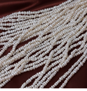 Vue macro de perles d'eau douce blanches sur soie pour la création de bijoux