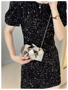 Detail of champagne gold geometric acrylic clutch bag with shiny metal chain strap