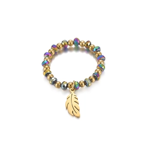 Macro view of elastic beaded ring featuring a golden feather charm and iridescent beads
