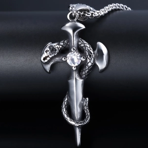 Macro view of gothic silver cross pendant with a serpent wrap and crystal center