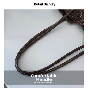 Detailed macro view of deep brown leather bag handle with white contrast stitching