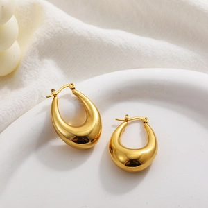 Macro detail of glossy 18K gold plated chunky hollow oval teardrop hoop earrings