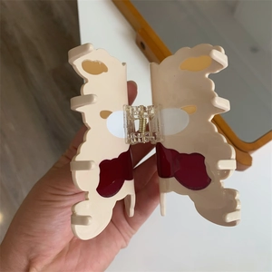 Detail showing the inner metal spring and marble texture of the butterfly hair claw clip