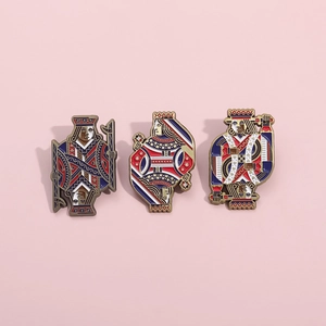 Set of three playing card J Q K enamel pins with metallic details on pink backdrop