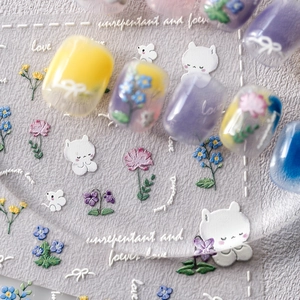 Detailed macro view of frosted floral nail art stickers with cute cat and mouse designs