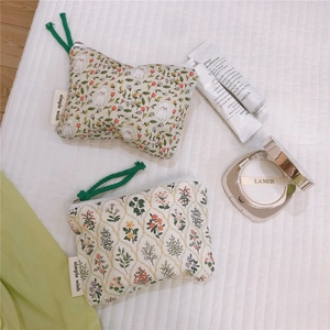 Detail of cotton zipper pouches featuring floral prints and long green rope pulls