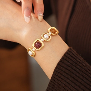 Détail d'un bracelet vintage doré avec perles et pierres colorées portées au poignet
