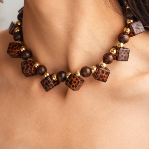 Detail of leopard print acrylic beads and wooden spheres on a bohemian choker necklace