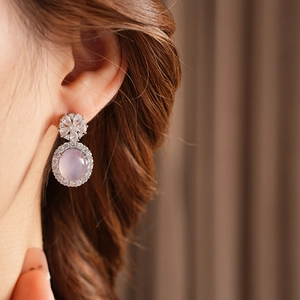 Gros plan de boucles d'oreilles vintage avec pierres roses et détails de fleurs en diamants
